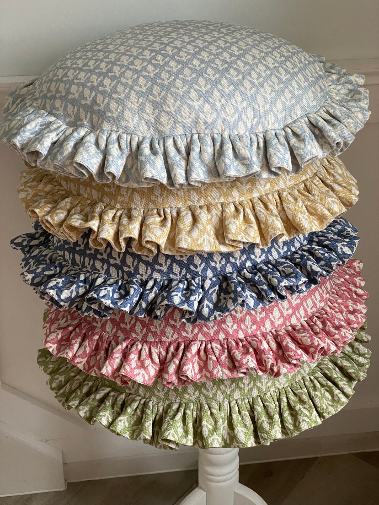 A LIMITED EDITION FRILLY CIRCULAR CUSHION IN BUD LEAF A FABRIC DESIGN FROM THE ANDREW MARTIN GARDEN PATH COLLECTION